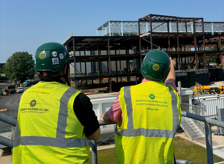 Project managers from Herman Goldner Co., Inc. overseeing mechanical construction at a commercial building site in Philadelphia, ensuring quality and safety.