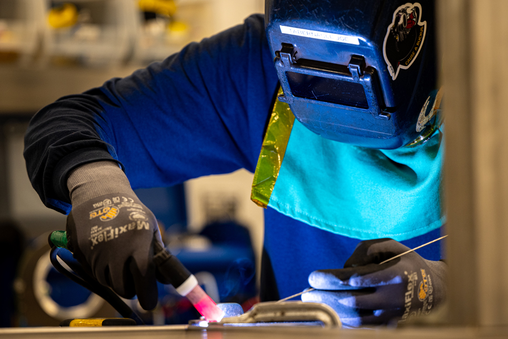 Certified welder at Herman Goldner Co., Inc. performing high-precision TIG welding on stainless steel piping for mechanical and process systems.