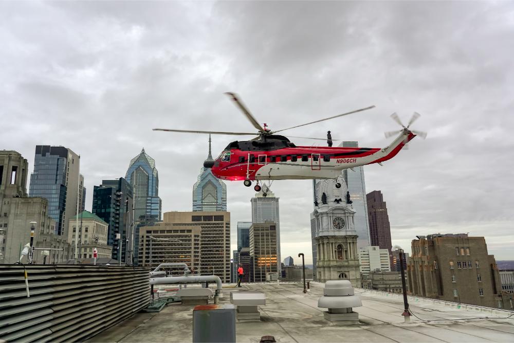 Helicopter approaches 1234 Market Street roof to lift an air-cooled chiller while crews stage below