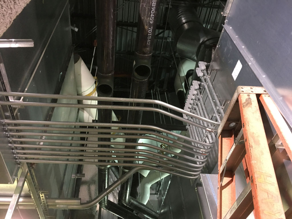 Arena mechanical space with ductwork and new BAS sensor wiring during retrofit