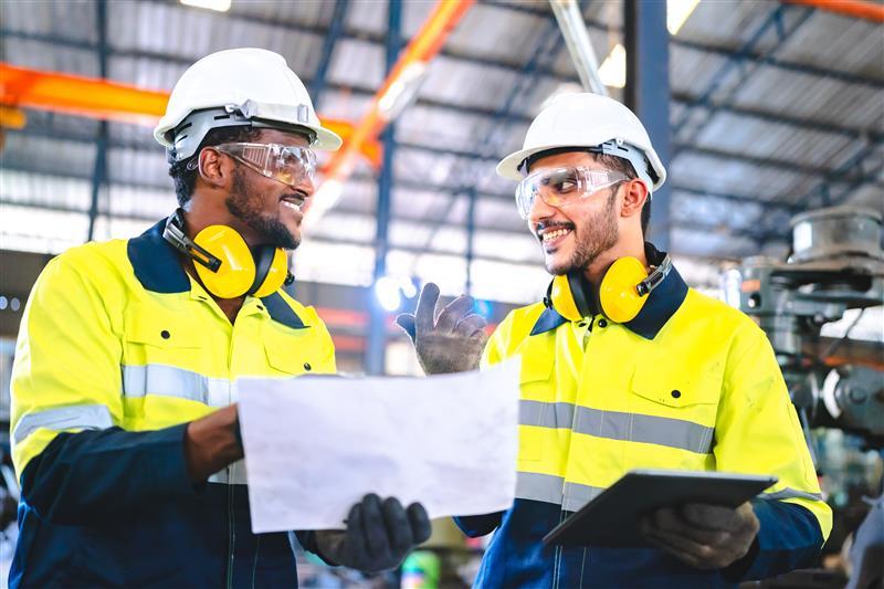 Herman Goldner Co., Inc. employees conducting weekly safety training and reviewing mechanical site plans.